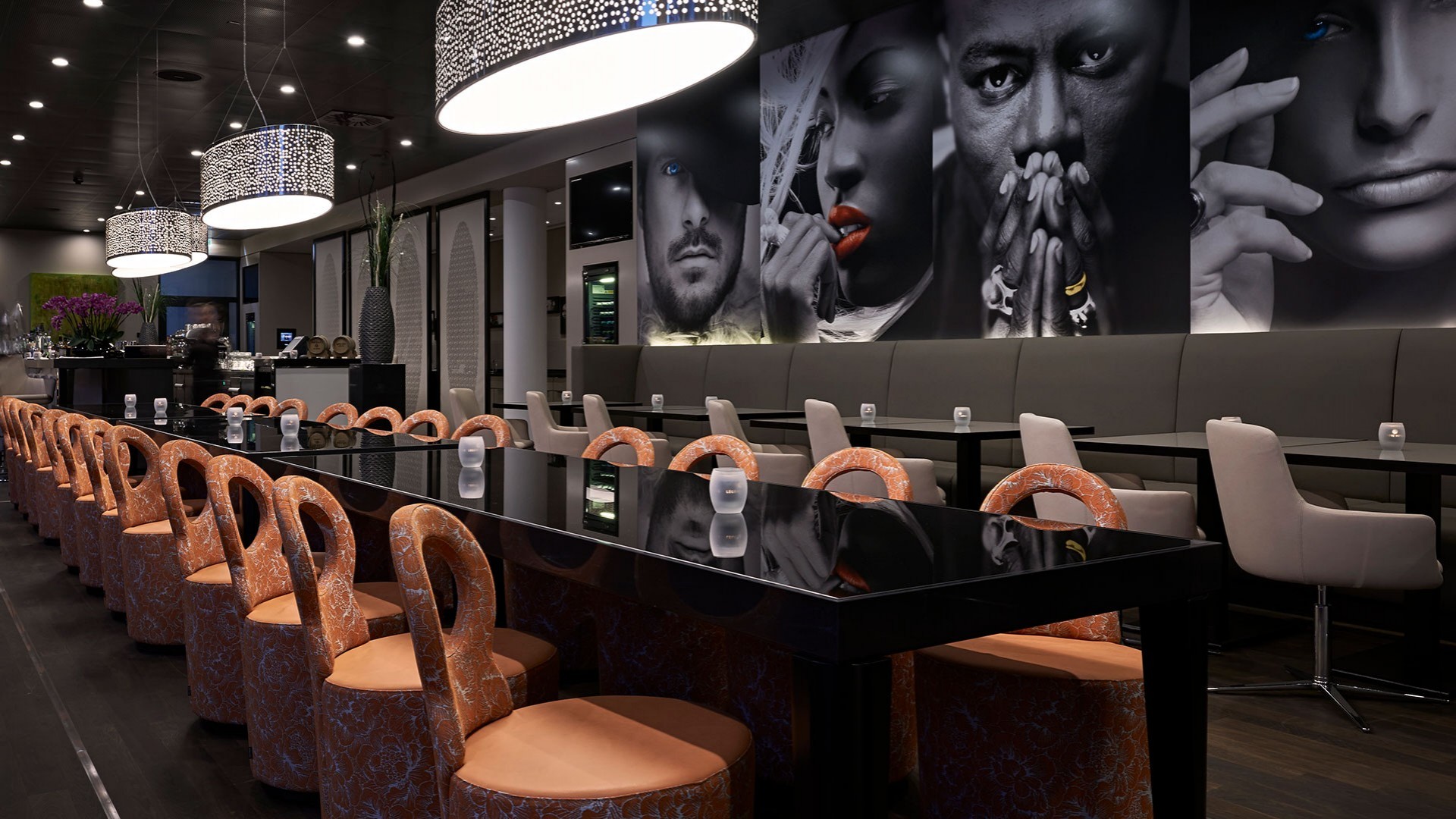 Stylish restaurant with black high-gloss tables and orange swivel chairs